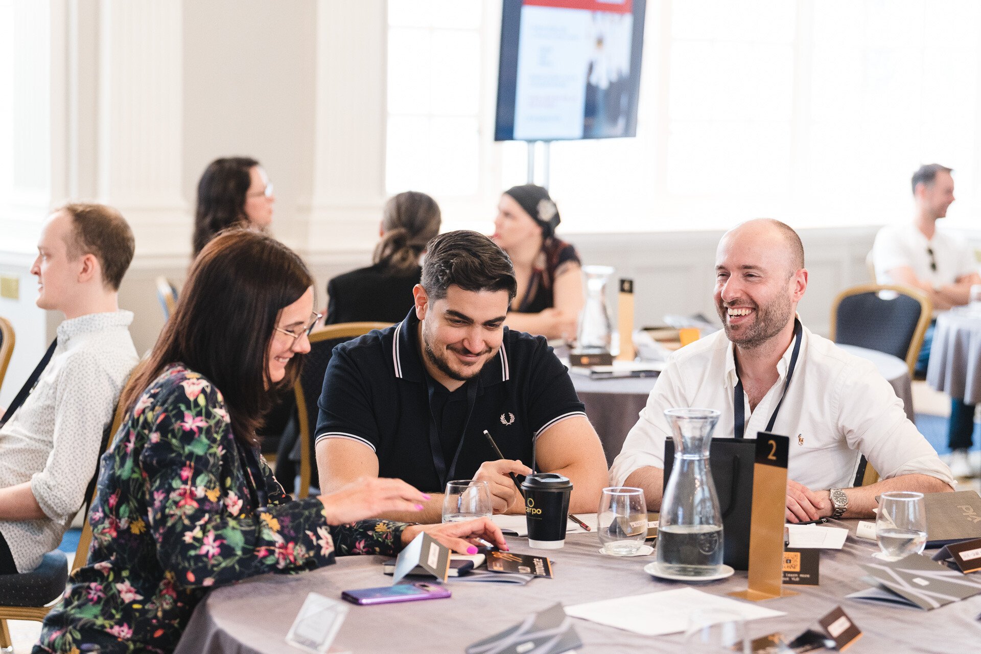 A photo of a group with one woman and two men energetically discussing strategy.